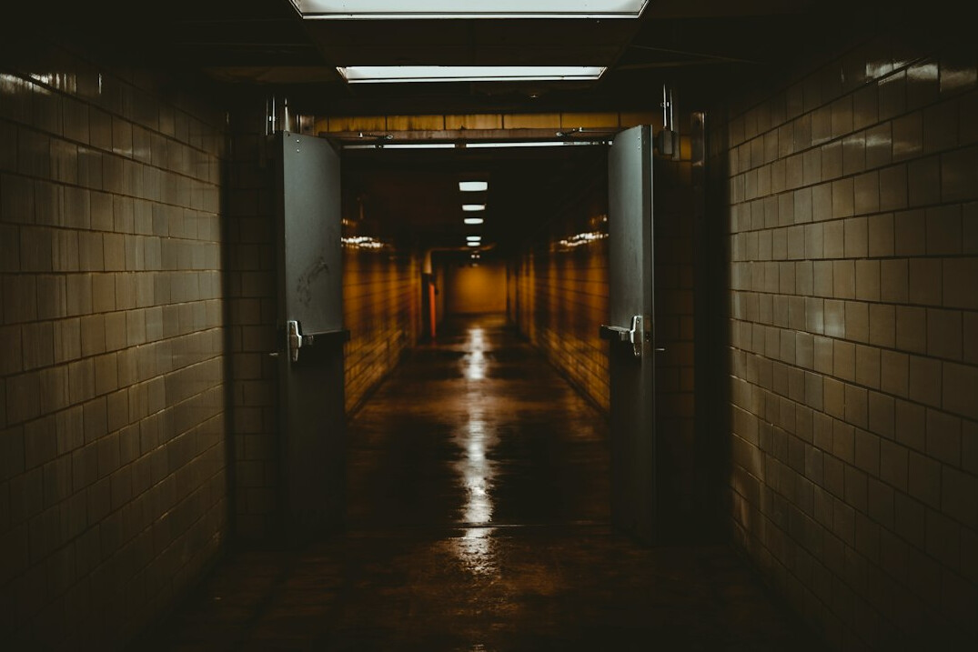 person walking in dark corridor